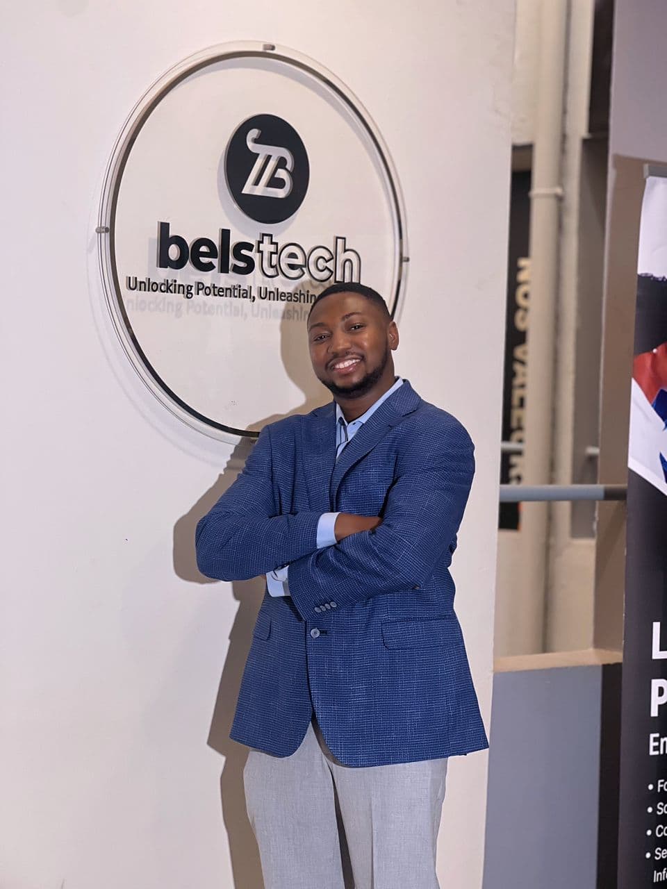 Man standing in front of the Belstech sign